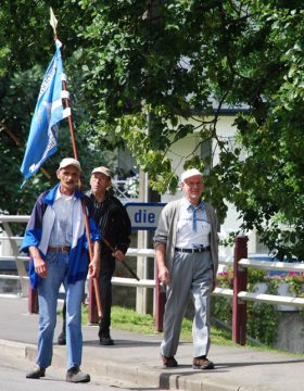 Pilger bei der Überquerung der Our - Albert Velz mit der Pilgerfahne (li)