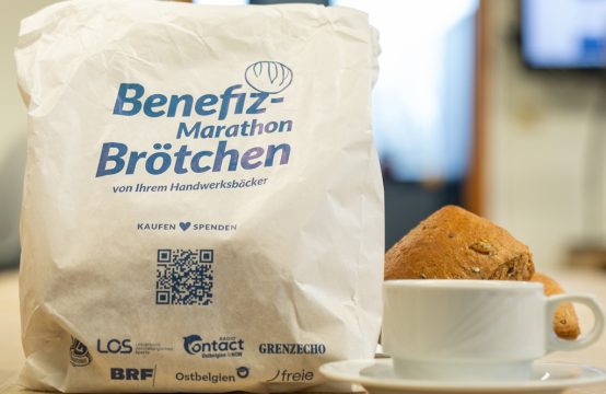 Brötchentüte steht mit einer Tasse Kaffee auf einem Tisch